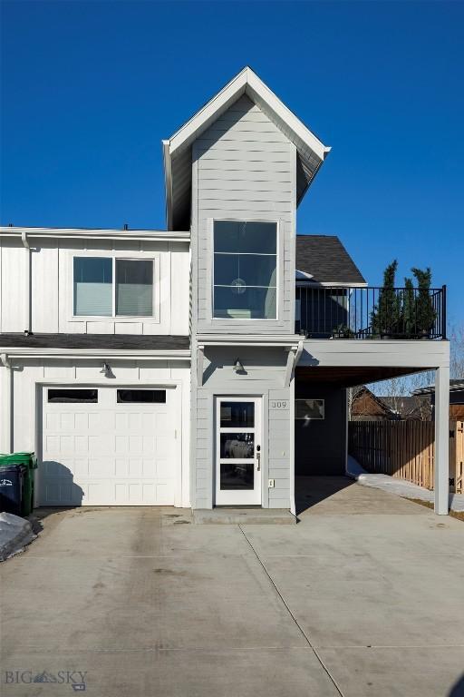 view of front of property featuring a balcony, concrete driveway, and a garage