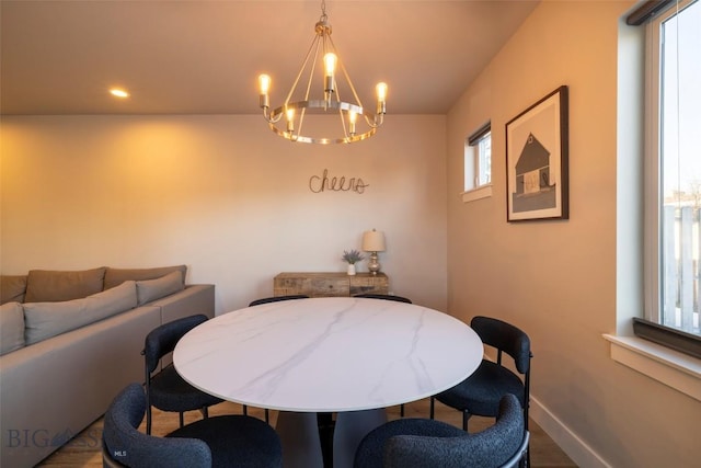 dining room with an inviting chandelier, wood finished floors, recessed lighting, and baseboards