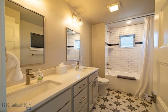 bathroom featuring tile patterned floors, double vanity, toilet, and a sink