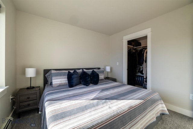 carpeted bedroom featuring a walk in closet, baseboards, baseboard heating, and a closet