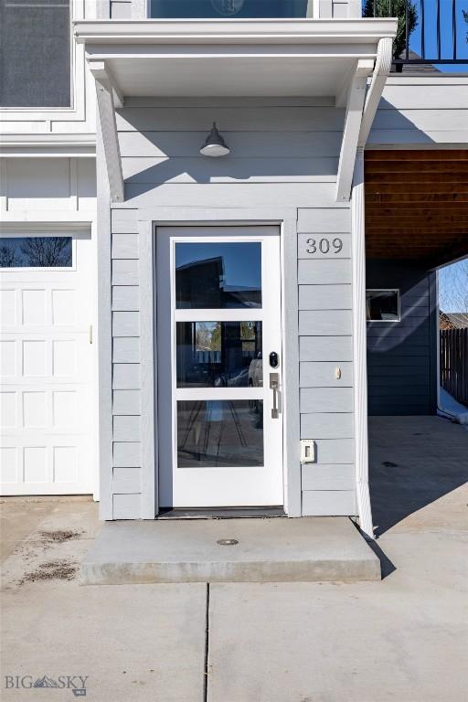 entrance to property with an attached carport and a garage