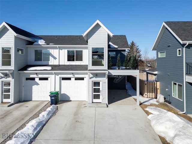 view of front facade featuring board and batten siding, a shingled roof, driveway, and a garage