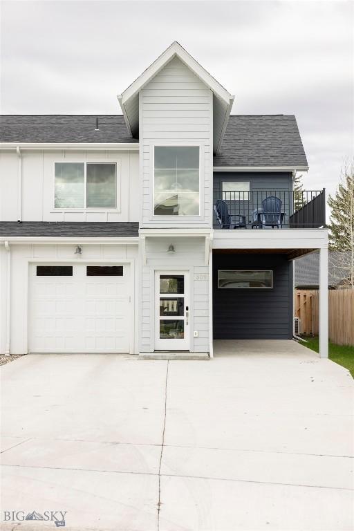 309 Meriwether, Bozeman, MT 59718 - view of front facade featuring fence, an attached garage, board and batten siding, concrete driveway, and a balcony