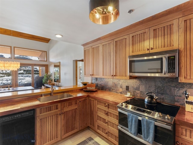 kitchen with butcher block countertops, backsplash, stainless steel appliances, and a sink