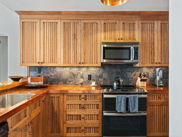 kitchen with tasteful backsplash, appliances with stainless steel finishes, and a sink