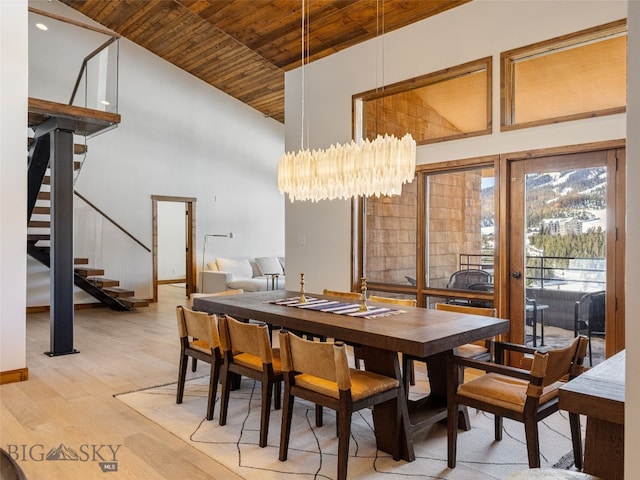 dining space featuring stairway, high vaulted ceiling, wooden ceiling, a notable chandelier, and light wood-type flooring