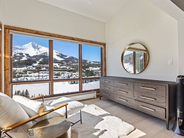 sitting room featuring light wood finished floors, a mountain view, and vaulted ceiling