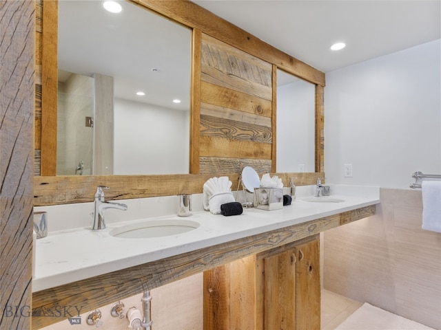 bathroom with a sink, an enclosed shower, double vanity, and recessed lighting