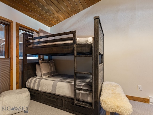 carpeted bedroom with baseboards, wood ceiling, and vaulted ceiling