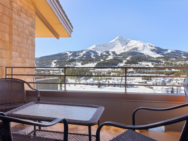 snow covered back of property with a mountain view