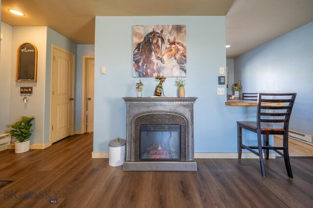 interior space featuring recessed lighting, baseboards, wood finished floors, and a glass covered fireplace