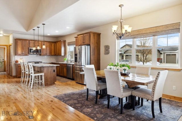 dining space featuring recessed lighting, a notable chandelier, light wood-style flooring, and baseboards