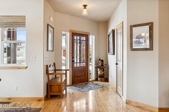 foyer with light wood-type flooring and baseboards