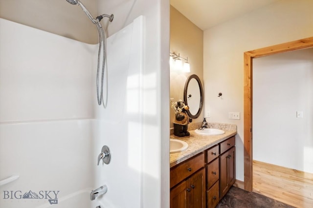 full bathroom with double vanity, washtub / shower combination, and a sink