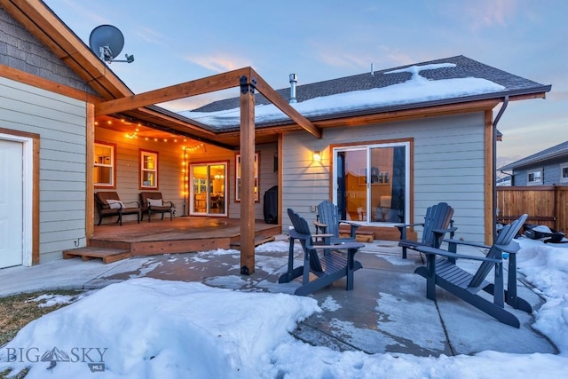 snow covered property featuring a wooden deck and fence