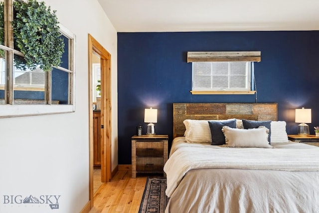 bedroom with wood finished floors and baseboards