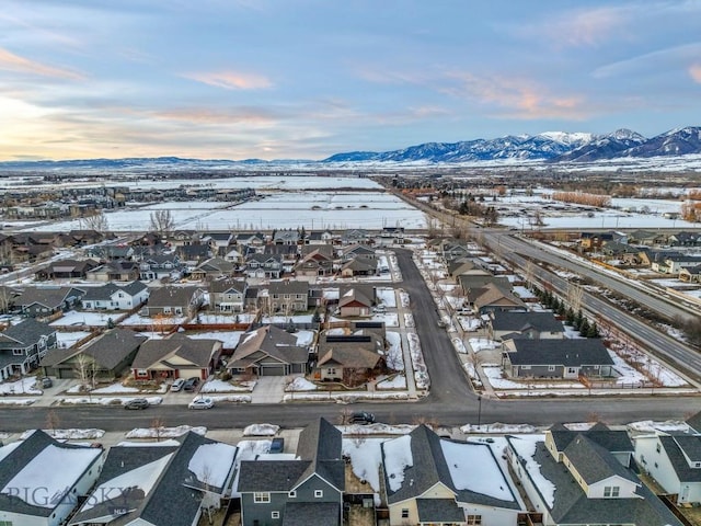 snowy aerial view with a residential view and a mountain view