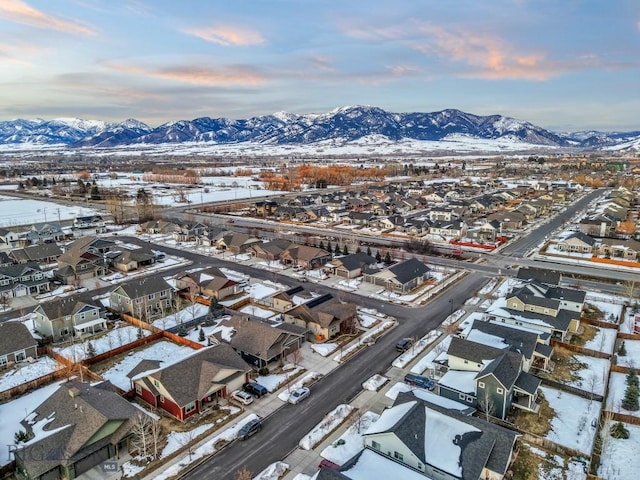 snowy aerial view with a residential view and a mountain view