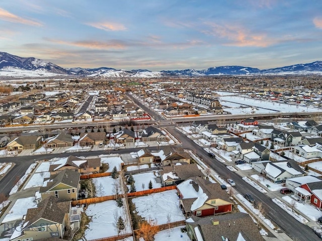 snowy aerial view featuring a residential view and a mountain view