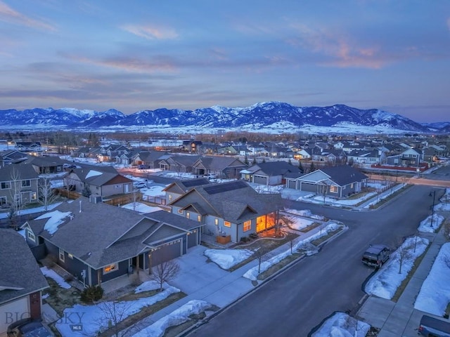 snowy aerial view featuring a residential view and a mountain view