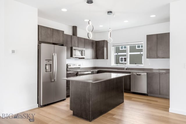 kitchen featuring pendant lighting, dark brown cabinets, light wood-type flooring, and stainless steel appliances