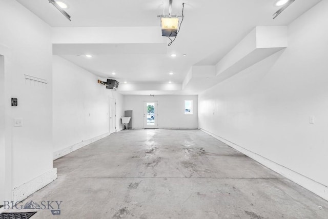 garage featuring recessed lighting, baseboards, and a garage door opener