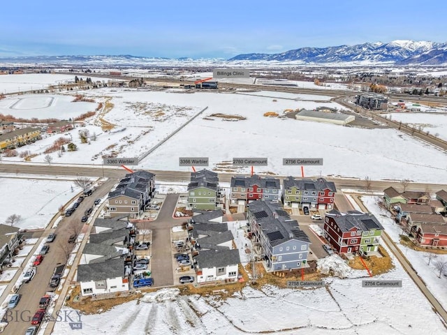 snowy aerial view with a residential view and a mountain view