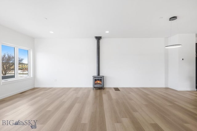 unfurnished living room with visible vents, recessed lighting, light wood-type flooring, and baseboards