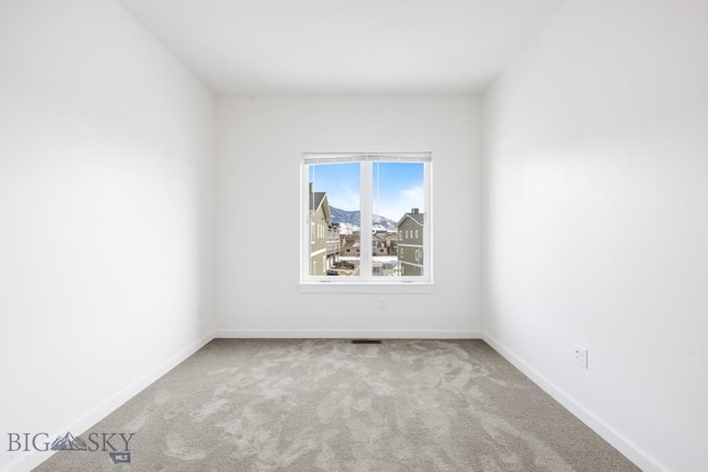 empty room with visible vents, baseboards, and carpet