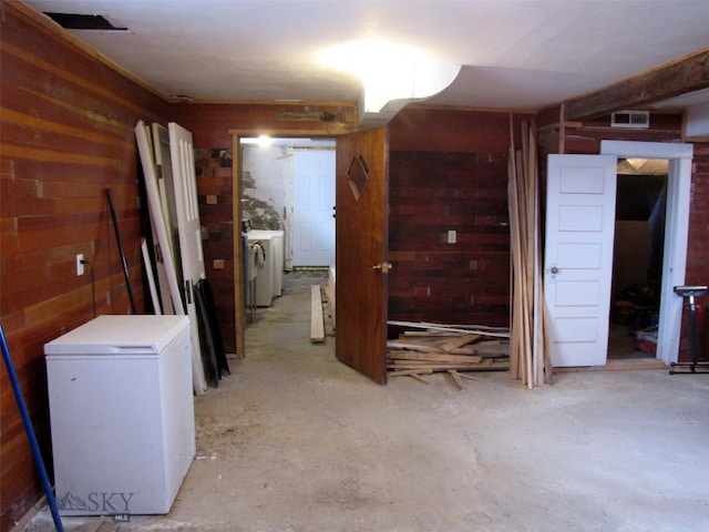 interior space with washer / dryer, wooden walls, and visible vents