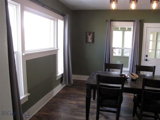 dining space featuring dark wood-type flooring and baseboards