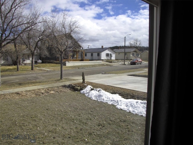 view of road with street lights, sidewalks, and a residential view