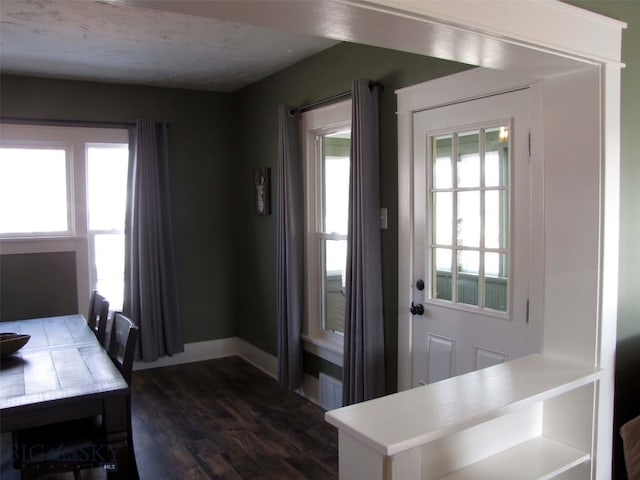 doorway featuring visible vents, dark wood-type flooring, and baseboards