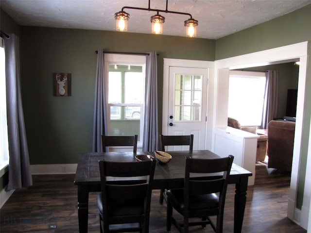 dining area featuring dark wood finished floors and baseboards