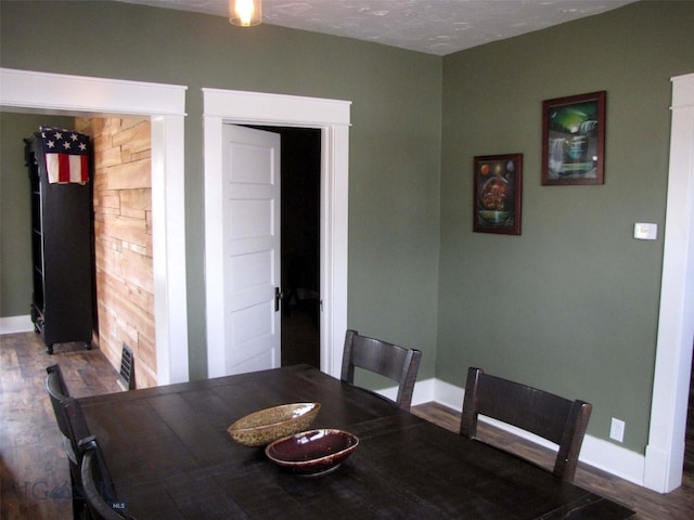 dining space with baseboards and wood finished floors