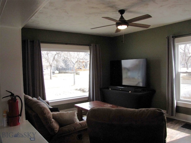 living area featuring visible vents, ceiling fan, and wood finished floors