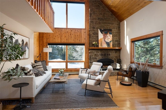 living area featuring wood ceiling, a fireplace, high vaulted ceiling, and wood finished floors