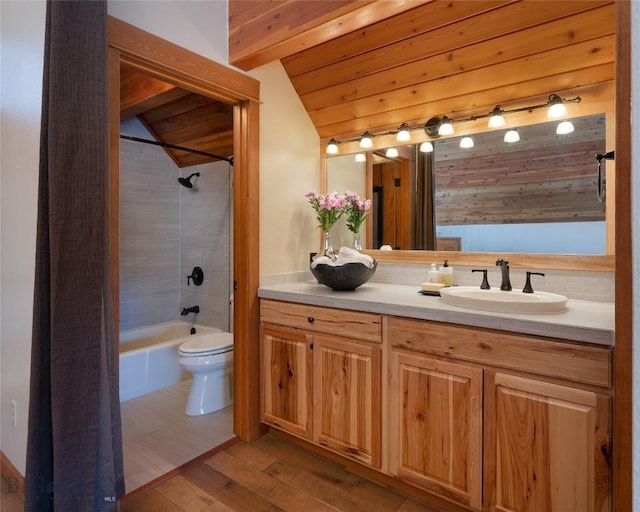 bathroom featuring toilet, wood finished floors, tub / shower combination, vaulted ceiling with beams, and vanity