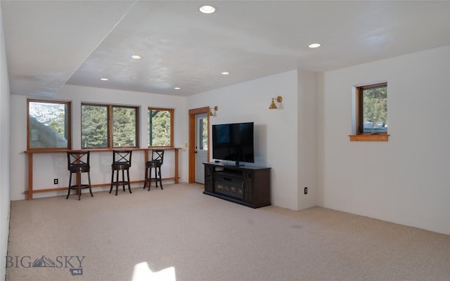 carpeted living area featuring recessed lighting, a healthy amount of sunlight, and a dry bar