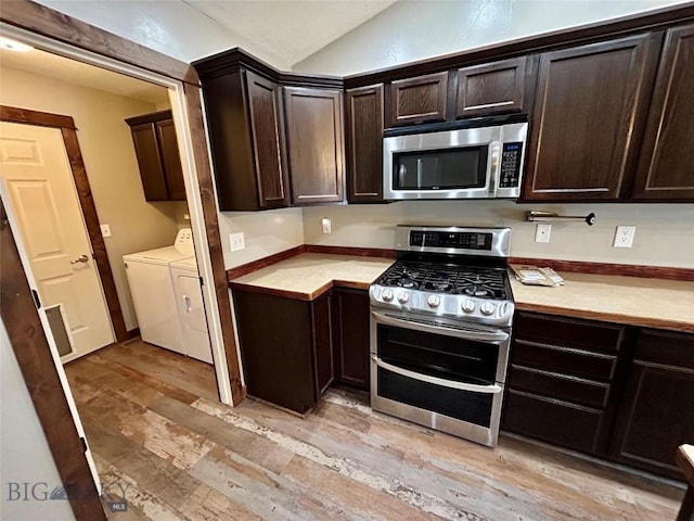 kitchen featuring light wood-type flooring, stainless steel appliances, independent washer and dryer, and dark brown cabinets