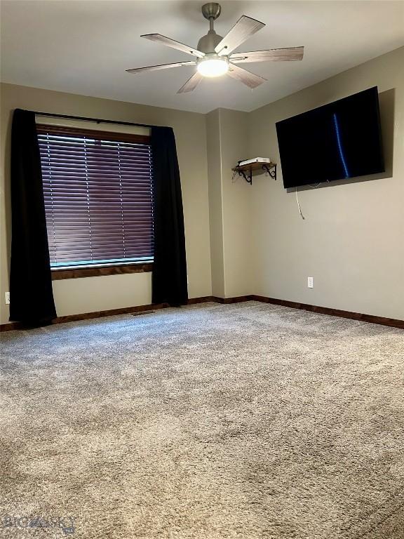 unfurnished room featuring a ceiling fan, baseboards, and carpet floors