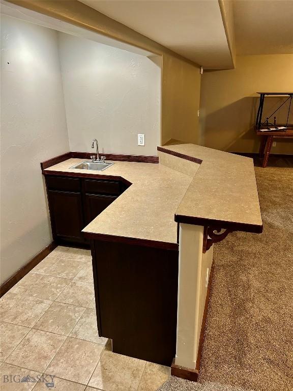 kitchen featuring baseboards and a sink