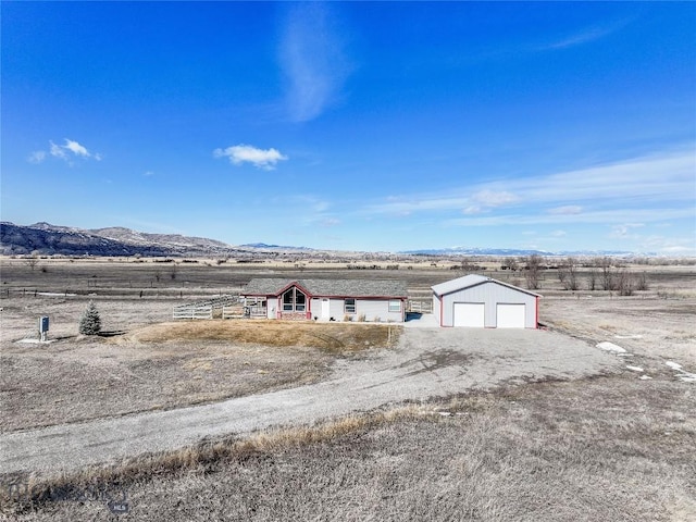 18287 Haasakker Rd, Three Forks, MT 59752 - view of yard featuring a garage, a mountain view, an outdoor structure, and a view of countryside