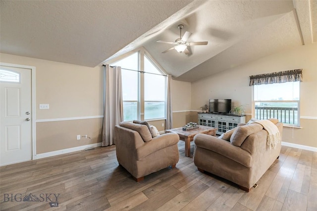 18287 Haasakker Rd, Three Forks, MT 59752 - living room with a textured ceiling, ceiling fan, light wood finished floors, and vaulted ceiling