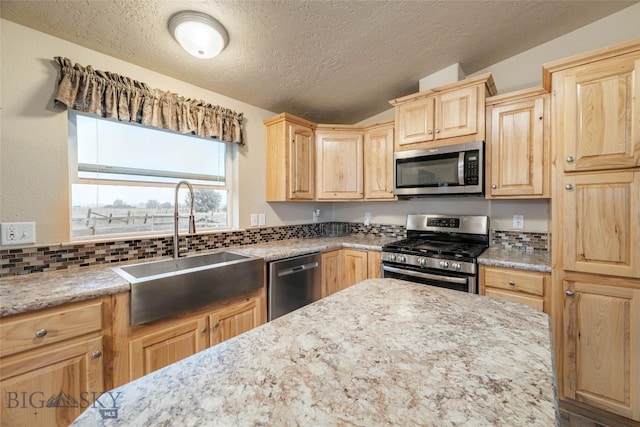 18287 Haasakker Rd, Three Forks, MT 59752 - kitchen with stainless steel appliances, light brown cabinets, a textured ceiling, decorative backsplash, and light stone countertops
