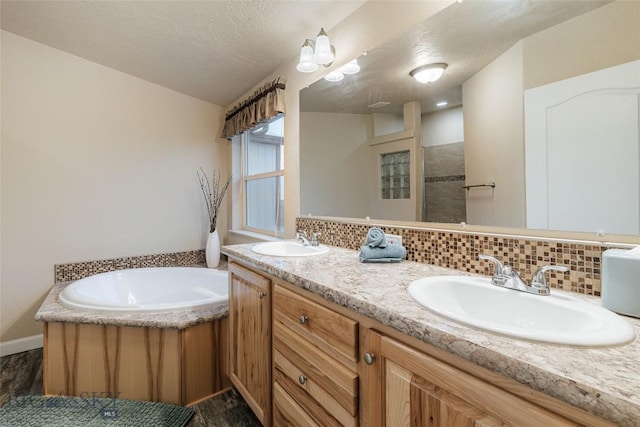 18287 Haasakker Rd, Three Forks, MT 59752 - full bathroom featuring double vanity, a bath, tasteful backsplash, a textured ceiling, and wood finished floors
