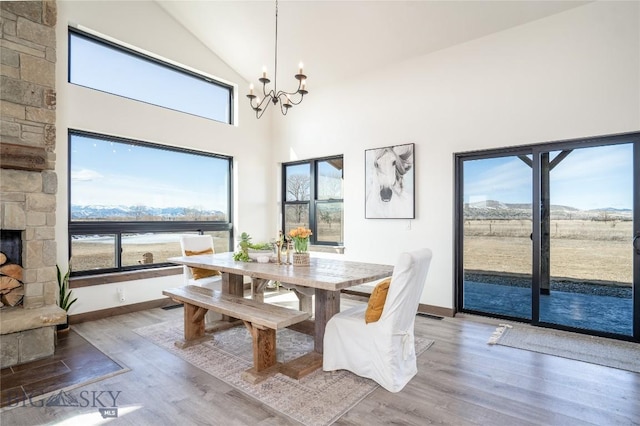 18287 Haasakker Rd, Three Forks, MT 59752 - dining room featuring a chandelier, light wood finished floors, plenty of natural light, and high vaulted ceiling