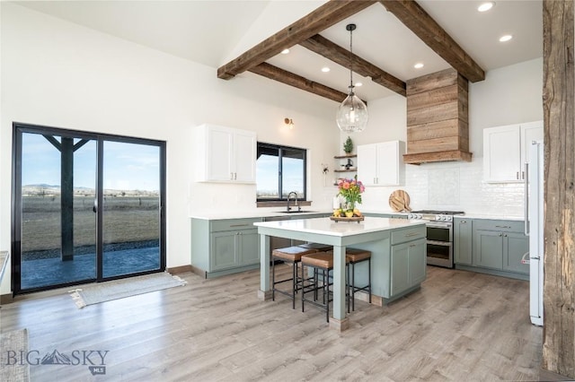 18287 Haasakker Rd, Three Forks, MT 59752 - kitchen with range with two ovens, custom exhaust hood, a breakfast bar area, a center island, and backsplash