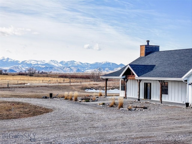 18287 Haasakker Rd, Three Forks, MT 59752 - view of side of property featuring a chimney, board and batten siding, a mountain view, and a shingled roof