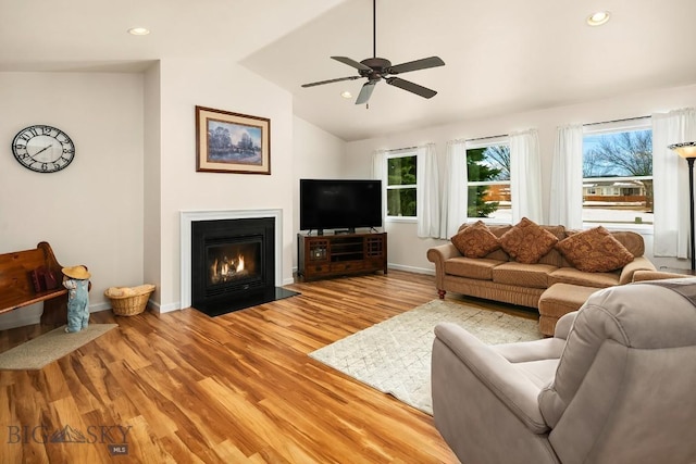 living room with light wood finished floors, baseboards, a fireplace with flush hearth, vaulted ceiling, and recessed lighting